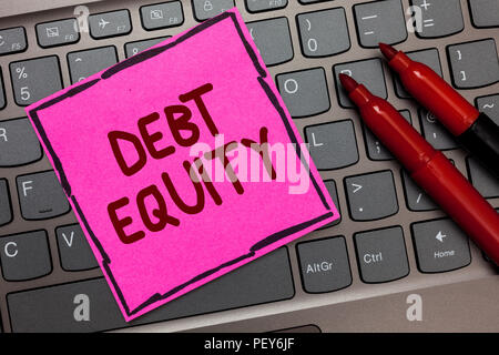 Text sign showing Debt Equity. Conceptual photo dividing companys total liabilities by its stockholders Pink paper keyboard Inspiration communicate id Stock Photo