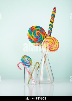 Laboratory glassware with candy canes and lollipops. Stock Photo