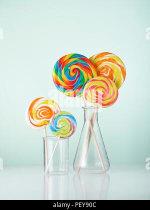 Laboratory glassware with lollipops. Stock Photo