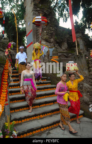 Women carrying offerings on their heads, Pura Dalem, Hindu temple in Ubud, Bali. Indonesia. Stock Photo