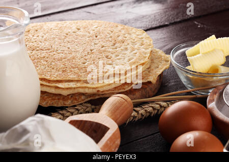 Homemade crepes served with fresh raspberrries and powdered sugar on rustic table Stock Photo