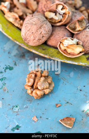Walnut kernels and whole walnuts on rustic old table Stock Photo