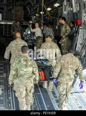 A 455th Expeditionary Medical Group team loads the remaining equipment used to save the life of a NATO ally, who required Extracorporeal Membrane Oxygenation team support, onto an aeromedical evacuation transport at Bagram Air Field, Afghanistan, on Feb. 18, 2016. The ECMO team, dispatched from San Antonio Military Medical Center, uses technology that bypasses the lungs and infuses the blood directly with oxygen, while removing the harmful carbon dioxide from the blood stream. The patient was airlifted to Landstuhl Regional Medical Center, Germany, where he will receive 7 to 14 days of additio Stock Photo