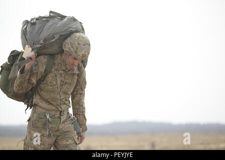 A Paratrooper with 82nd Airborne Division walks off of Sicily Drop Zone at Fort Bragg, N.C., following a static line jump during the Saturday Proficiency Jump Program (SPJP) on Feb. 20, 2016. The SPJP builds proficiency, experience, and confidence of individual Paratroopers, ensuring the XVIII Airborne Corps remains ready for contingency response missions. (US Army Photo by Sgt. Tierney P. Curry)(Released) Stock Photo