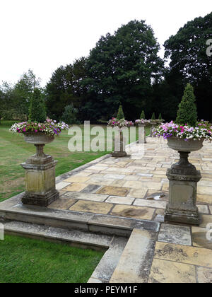 Grecian Stone Urns on very large areas of wonderful old real Yorkstone slabs around a private large home in Yorkshire. Property released Stock Photo