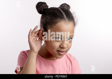 adorable nice black-haired girl is beiing checked her hearing in the hospital. acute, deffective, impaired , normal hearing Stock Photo