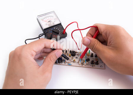 Technician hand with multimeter probes repairing circuit board Stock Photo