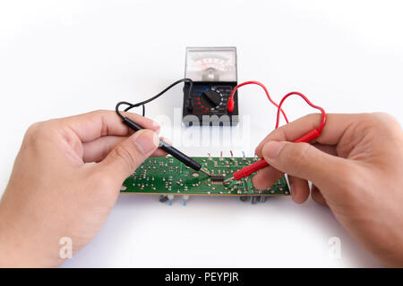 Technician hand with multimeter probes repairing circuit board Stock Photo