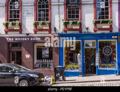 Edinburgh, Scotland, UK - June 13, 2012: The brown facade of The Whisky Shop and the blue facade of Cuttea Sark souvenir store along Victoria Street w Stock Photo
