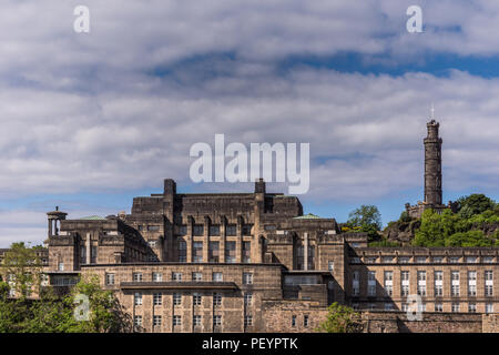 Edinburgh, Scotland, UK - June 13, 2012: Large brown building was Old Royal High school and abandoned site of New Scottish Assembly with Nelson Monume Stock Photo