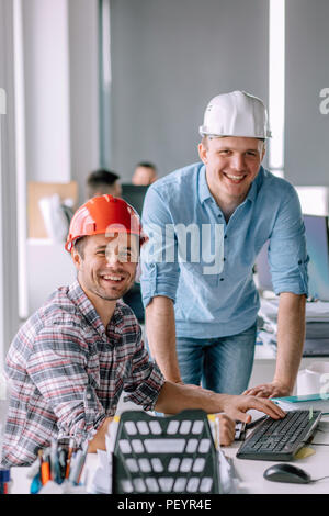 handsome smiling architects working in the office building. workers with good mood. close up portrait Stock Photo