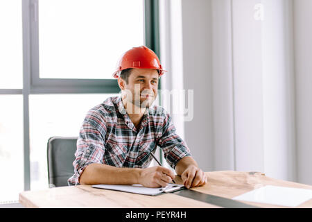 positive beaded constructor making notes in the notepad in the office with panorama window. close up photo Stock Photo