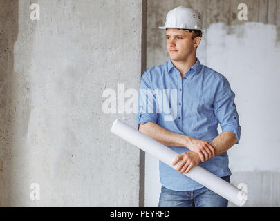 thoughtful attractive guy in casual outfit is holding a draft and looking aside. job concept. Stock Photo