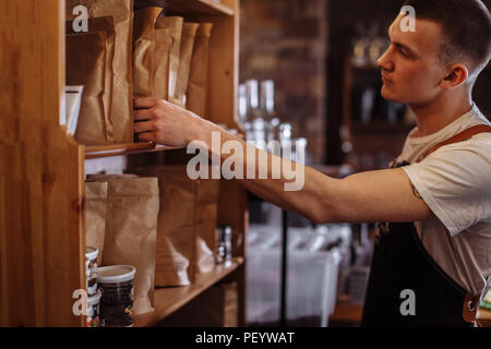 a handsome man is choosing the package with good coffee seeds Stock Photo