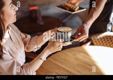 nice woman is thanking a waiter for a cup of latte Stock Photo