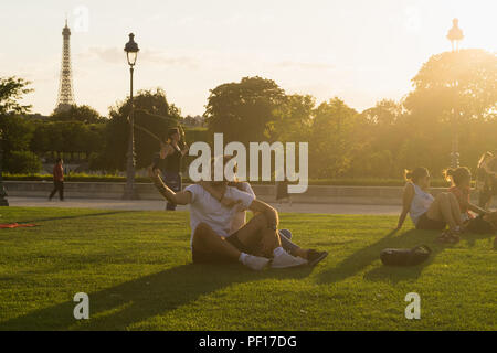 Paris couple scene - a couple taking a selfie at the Tuileries Garden with the Eiffel Tower in the background. Stock Photo