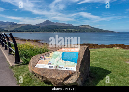 Stone with interpretation panel inserted at the beach at Brodick Isle of Arran North Ayrshire Scotland UK with Goat Fell across Brodick Bay Stock Photo