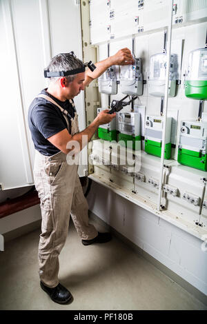 Electrician testing fuse box or switch box with measuring device Stock Photo
