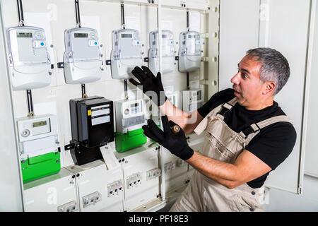 Funny electrician doing electrical repair in switchboard Stock Photo