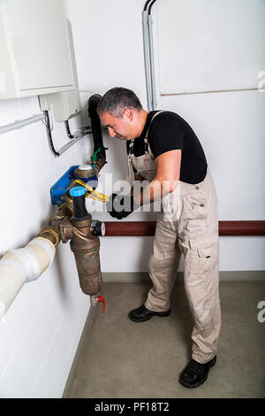 Plumber repairing metallic water pipes with wrench Stock Photo