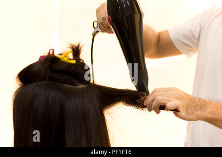 Man hairdresser using blower to dry customer hair  Stock Photo