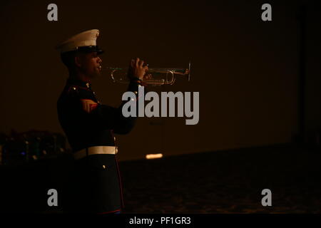A Marine with the 1st Marine Division Band plays “Taps” during a professional dinner at Harrah’s Resort Feb. 25, 2016. Sergeants major, master gunnery sergeants, and master chief petty officers with I Marine Expeditionary Force came together to share and develop the leadership skills they have gained throughout their years in the Navy and Marine Corps, as well as discuss important events occurring in the nation. (U.S. Marine Corps photo by Sgt. Anna Albrecht/ Released) Stock Photo