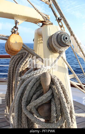 belaying pins, pulley, rope holder and boom on the main deck of a clipper ship at sea Stock Photo