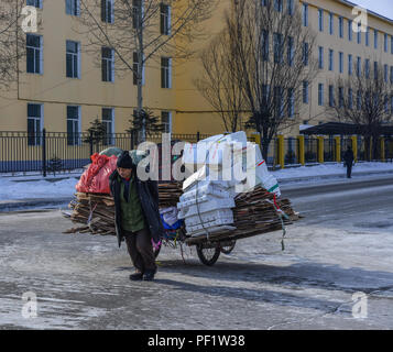 Harbin, China - Feb 21, 2018. A man carrying garbage on street in Harbin, China. Harbin is the capital of Heilongjiang, China northernmost province. Stock Photo