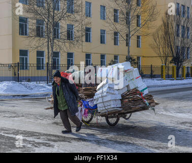 Harbin, China - Feb 21, 2018. A man carrying garbage on street in Harbin, China. Harbin is the capital of Heilongjiang, China northernmost province. Stock Photo