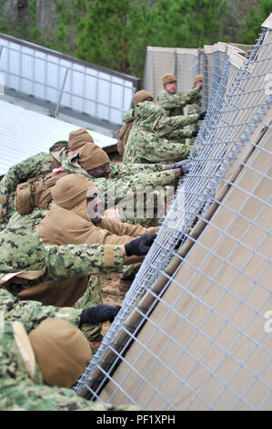 CAMP SHELBY, Miss. (Feb. 24, 2016) Seabees assigned to Naval Mobile Construction Battalion 11 stand up the Hesco Barriers after returning to the Forward Operating Base (FOB), FOB “Pipe wrench” due to tornado and flash flood warnings during NMCB-11 field training exercise. Upon successful completion of the exercise and final evaluation problem, NMCB-11 will become deployment ready. (U.S. Navy photo by Mass Communication Specialist 1st Class Michael C. Barton/Released) Stock Photo