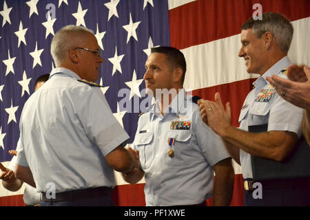 Rear Adm. Scott Buschman, commander Coast Guard Seventh District, Miami, presents an Air Medal to Lt. David McCarthy, a pilot at Air Station Clearwater, Fla., during an awards ceremony at the station Feb. 24, 2016. McCarthy was commended for his performance as air craft commander in saving 12 lives during Hurricane Joaquin. (U.S. Coast Guard photo by Auxiliarist Joe Perez) Stock Photo