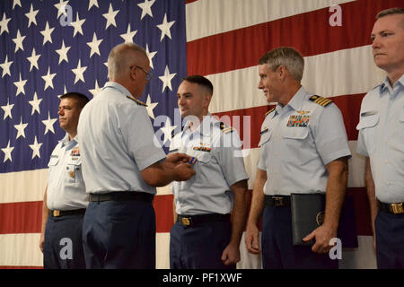 Rear Adm. Scott Buschman, commander Coast Guard Seventh District, Miami, presents an Air Medal to  Lt. Rick Post, a pilot at Air Station Clearwater, Fla., during an awards ceremony at the station Feb. 24, 2016. Post was commended for his performance as a co-pilot in saving 12 lives during Hurricane Joaquin. (U.S. Coast Guard photo by Auxiliarist Joe Perez) Stock Photo