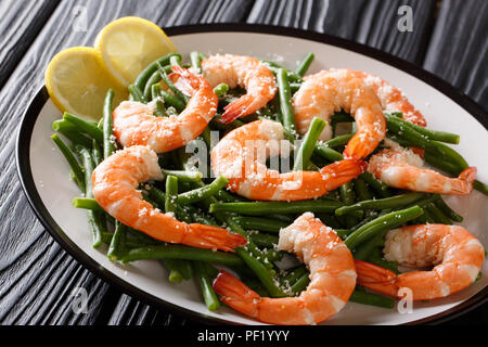 Delicious shrimp salad with green beans, cheese and lemon close-up on a plate on the table. horizontal Stock Photo