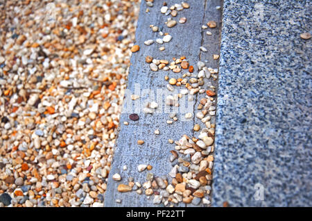 Three stripes of multicolored gravel, grey concrete and speckled marble, summer, Spain Stock Photo