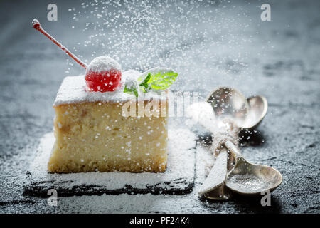 Falling powdered sugar on cheesecake with cherries Stock Photo