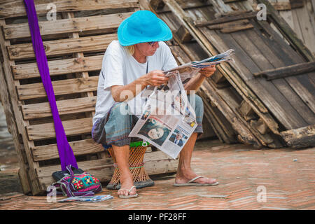 Kathmandu,Nepal - Aug 11,2018: Foreign Tourist reading a nepali newspaper in basantapur Square,kathmandu. Stock Photo