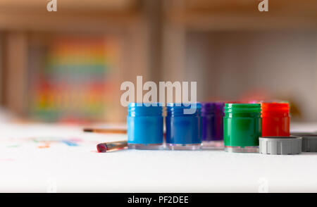 Opened bottles of poster color and brush on white background. Select focus shallow depth of field. Stock Photo