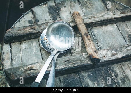 Skimmer and Ladle, kitchen utensils on a wooden lid Stock Photo