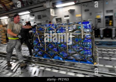 Airmen unload a pallet of water from a Joint Base Charleston C-17 Globemaster III in St. Croix, Virgin Islands, Sept. 24, 2017. Members of the 14th Airlift Squadron, 437th Airlift Wing, delivered more than 129,000 pounds of food and water to St. Croix in support of relief efforts after Hurricane Maria. The mission to St. Croix marked the second mission the crew flew to the Virgin Islands for humanitarian aid in 48 hours. (Photo by Airman 1st Class Megan Munoz) Stock Photo