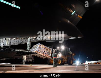 Airmen unload a pallet of water from a Joint Base Charleston C-17 Globemaster III in St. Croix, Virgin Islands, Sept. 24, 2017. Members of the 14th Airlift Squadron, 437th Airlift Wing, delivered more than 129,000 pounds of food and water to St. Croix in support of relief efforts after Hurricane Maria. The mission to St. Croix marked the second mission the crew flew to the Virgin Islands for humanitarian aid in 48 hours. (Photo by Airman 1st Class Megan Munoz) Stock Photo