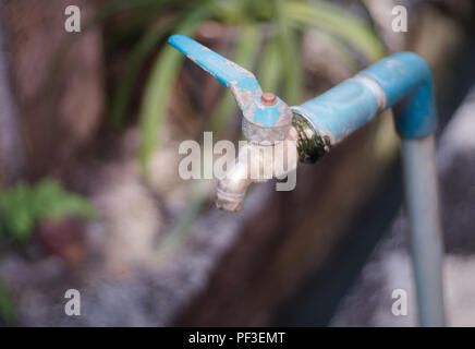 Old tap water dripping on a blurred background Stock Photo