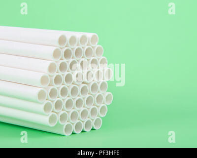Dozens of biodegradable eco-friendly paper straws bundled together facing forward on a green background with copy space. Many cities are now banning s Stock Photo