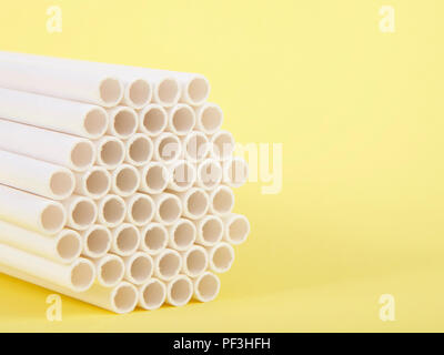 Dozens of biodegradable eco-friendly paper straws bundled together facing forward on a yellow background with copy space. Many cities are now banning  Stock Photo
