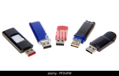 Multiple flash drives various colors and designs laying on white background, isolated. Stock Photo