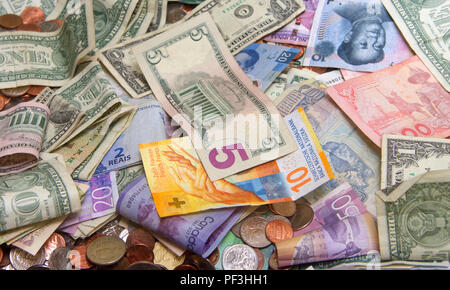 Close up on pile of many bank notes from various countries from around the world. U.S., German, Swiss, Canadian, Brazilian, Vietnamese, Mexican. Many  Stock Photo