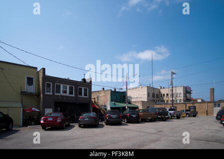 Back Alley and parking lot behind a row of retail businesses in downtown Ludington, Michigan, USA. Stock Photo