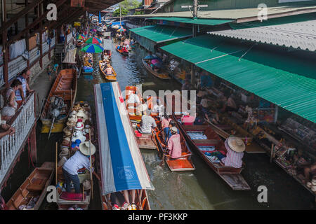 Damnoen Floating Market, Thailand, Nov.22, 2014, Tourists in boats and along sides of waterway shopping. Stock Photo