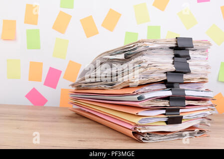 Important documents stacked high on the office desk,Adhesive note on the back. Stock Photo
