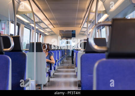 A near empty modern electric train carriage interior running on the train line between Thessaloniki and Larissa in Greece Stock Photo