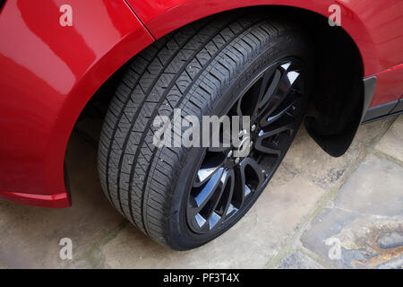 Range Rover Autobiography in Spectral Racing Red - ChromaFlair seen parked in old stone slab floored courtyard. Property released Stock Photo